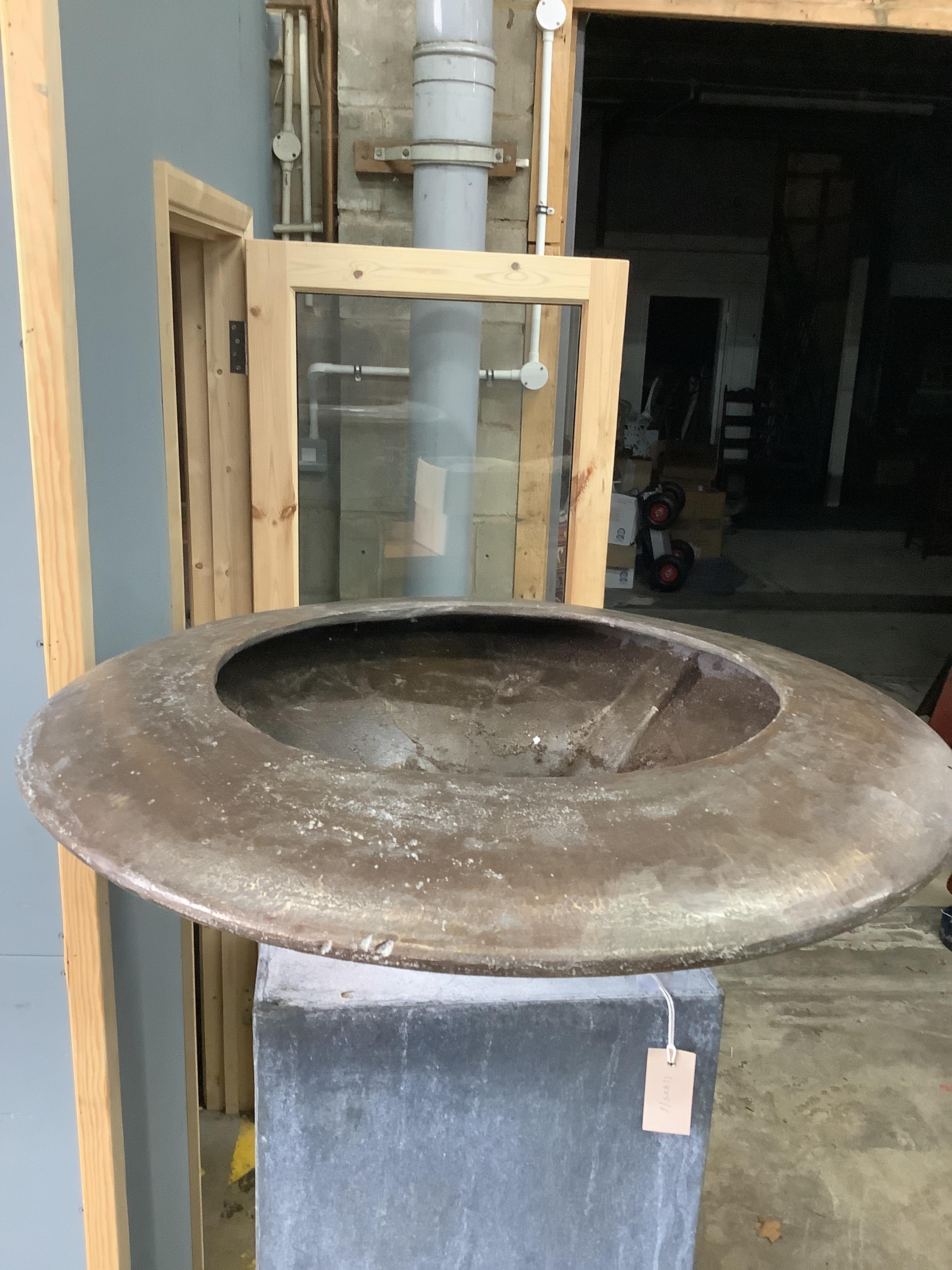 A circular bronze dish on square galvanised stand, height 160cm